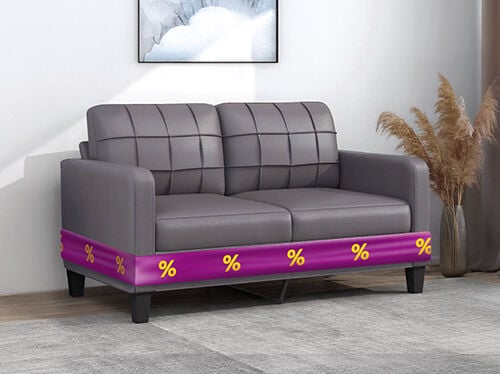 Grey sofa with purple ribbon showing discount icons, in a styled living room. Click to see the products in the offer.