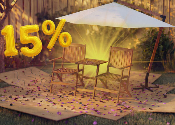 Two wooden outdoor chairs with a small table under a garden umbrella, surrounded by pink confetti and golden 15% discount balloons, highlighting a seasonal sale on umbrellas and sunshades.