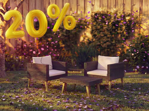 Outdoor rattan lounge chairs with cushions and a small table in a garden setting, decorated with pink confetti and golden 20% discount balloons, highlighting seasonal deals on garden lounge furniture.