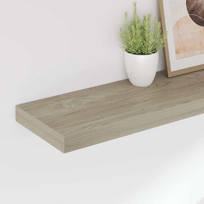 Close-up view of a single floating shelf with light wood finish
