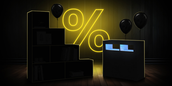 Black modular storage units with black balloons in front of a bright pink percentage symbol on a dark wooden floor.