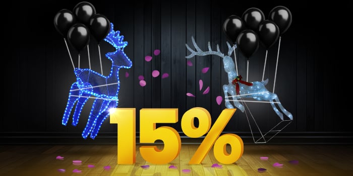 Two luminous reindeer decorations, one blue and one silver, with black balloons in front of a bright yellow 15% sign on a dark wooden floor.